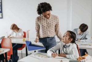 Smiling teacher and student connecting in a classroom, highlighting the supportive role of educators in psychoeducational assessments.