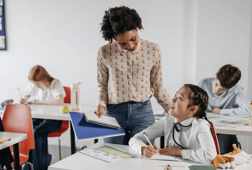 Smiling teacher and student connecting in a classroom, highlighting the supportive role of educators in psychoeducational assessments.