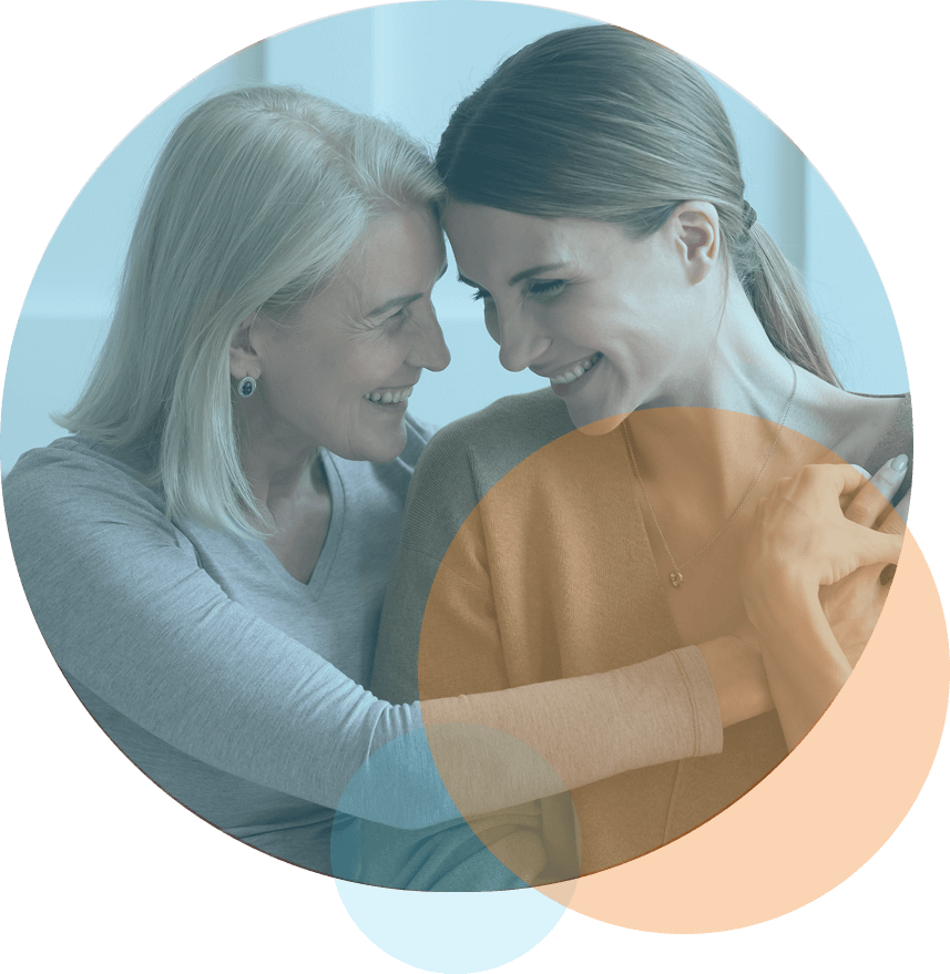 smiling mom and adult daughter embrace each other